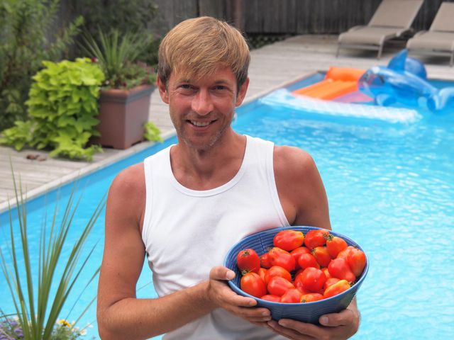 Richard Hake holds a bowl of fresh tomatoes on a sunny summer day by the pool on Fire Island.